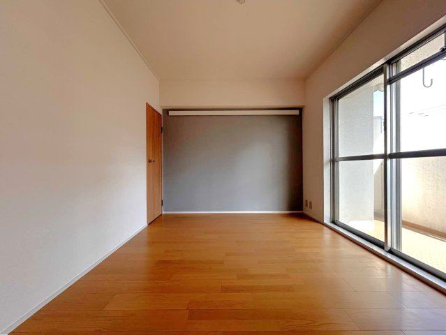 バルコニーに繋がる大きな窓から光が差し込む明るい部屋です。