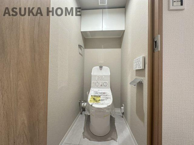 温水洗浄便座のトイレ設備です。トイレ上部にはあると便利な吊戸棚を設置！