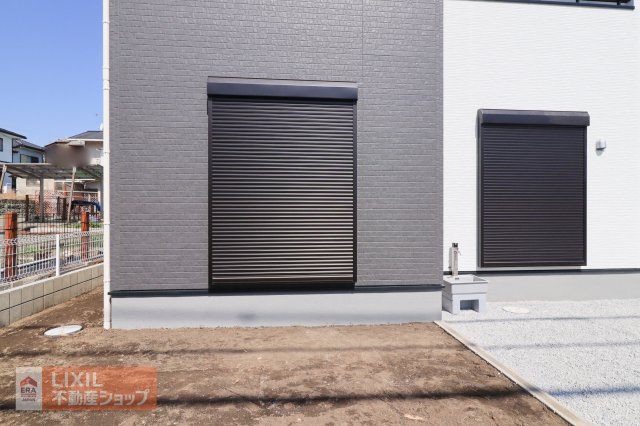 【防犯設備】現地完成写真。1階リビングには雨風の強い日にも役立つ防犯シャッターがついています。外壁に馴染む色合いで統一しデザイン性・防犯性とも◎
