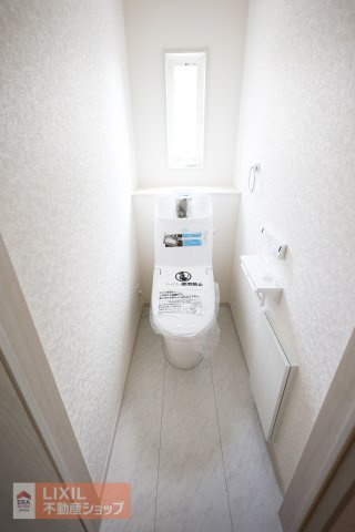 【トイレ】現地完成写真。温水洗浄暖房便座付き。小窓がついており採光と換気ができるようになっています。2階にもトイレがございます。