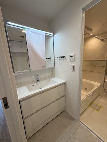 手元まで明るく照らすLED照明と、大型の三面鏡を備えたスタイリッシュな洗面台。