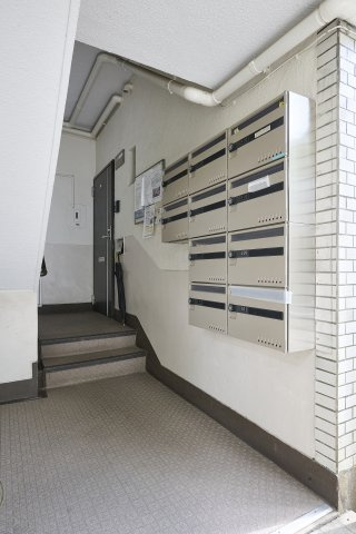 きれいに管理・清掃されたマンションの共用通路と集合ポスト。住人の方の出入りを見守る整理整頓された空間で、日々の管理体制の良さがうかがえる安心感のある共用設備です。