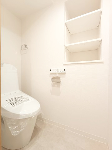 【トイレ】　洗浄機能付きトイレ。手の届きやすい位置に収納を備えています。トイレットペーパー等、買い置きもしやすそうです。