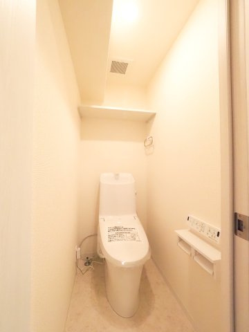 温水洗浄便座を備えた清潔感のあるトイレスペースです。上部にはトイレットペーパーのストックや清掃用品を収納できる吊り戸棚を完備。新規リフォーム済みで、いつでも快適にお使いいただける衛生的な空間です。