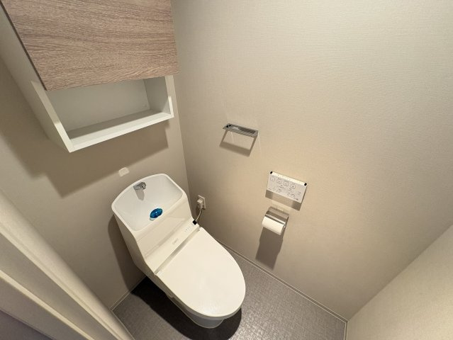 温水洗浄機能付き便座を備え、毎日快適に使用できます。上部には収納スペースが設けられており、トイレットペーパーや掃除用品などをまとめて収納可能。落ち着いた内装で使い勝手にも配慮されています。