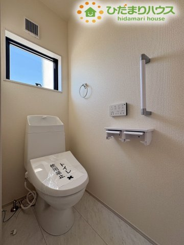 清潔感のある、温水洗浄便座付きのトイレです。小窓から自然光が差し込み、明るい空間になっています。手すりやタオル掛けもあり、使いやすい設備が整っております。