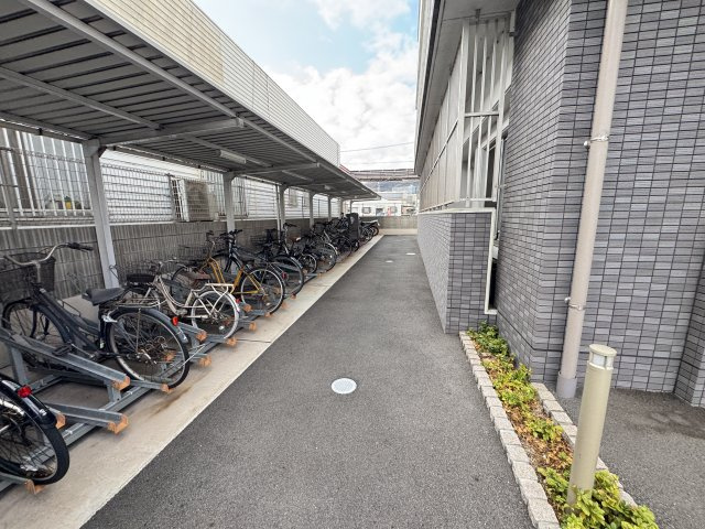 屋根付きの駐輪場が設けられており、大切な自転車を雨や直射日光から守りながら保管することができます。整然としたラック式で駐輪しやすく、通路も確保されているため出し入れもスムーズ。