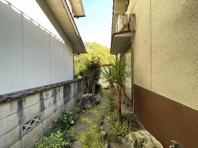 建物横の通路部分には植栽と飛び石が配置され、風情ある庭空間を演出。外部からの視線も入りにくく、落ち着いた雰囲気が魅力です。勝手口動線としても活用でき、日常の出入りにも便利なスペースです。