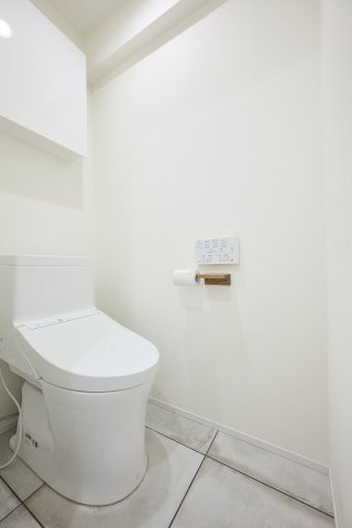 白ですっきりとまとめられた、清潔感のある温水洗浄便座付きトイレ。上部にはトイレットペーパーのストックや小物の収納に便利な吊戸棚を完備しており、限られた空間をスマートに美しく保てます。