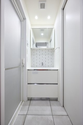 ダウンライトが手元や顔まわりを明るく照らす、機能的な洗面化粧台。鏡の裏や下部には収納スペースが用意されており、散らかりがちな洗面小物をスッキリと整理できます。忙しい朝の身支度もスムーズです。