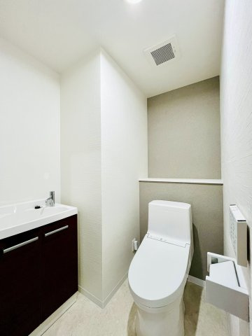 トイレ内にスッキリ収まる手洗キャビネットつき。温水洗浄便座は手元のパネルで操作でき使い勝手も良好。