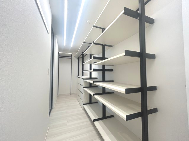 LED照明が輝く大容量のウォークインクローゼット。可動棚とハンガーパイプで美しく収納できます。