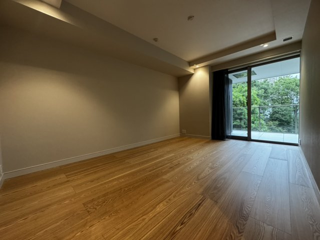 木の温もりに包まれるマスターベッドルーム。大きな窓の向こうには心地よい緑が広がります。