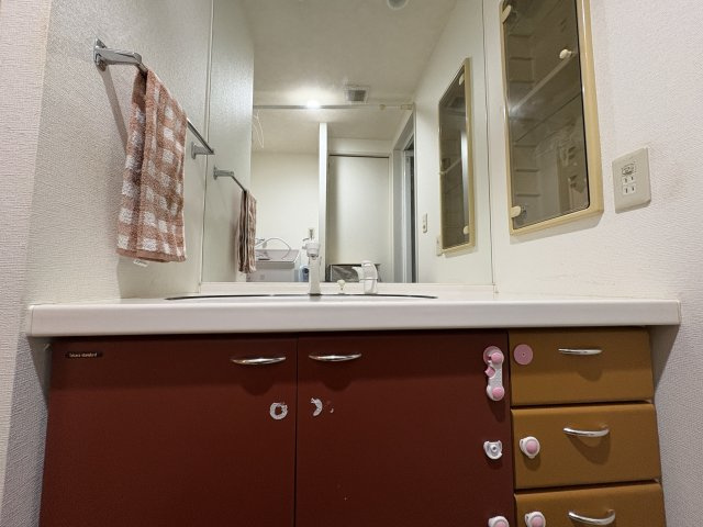 ワイドな洗面化粧台を備えた洗面室です。引き出し収納があり、タオルや日用品をすっきり整理できます。朝の身支度や帰宅後の手洗いもスムーズです。洗濯機置場も近く、家事動線に配慮された実用的な空間です。