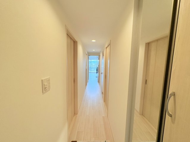 玄関からリビングへ続く廊下は、無駄の少ない動線で各居室へスムーズにアクセスできます。明るい色合いのフローリングと建具を採用しているため、室内全体に統一感のある上品な印象を演出しています。