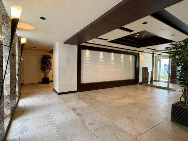石張りの床・壁が印象的な、ホテルライクなエントランスホール。落ち着きと品格を感じさせる共用空間です。