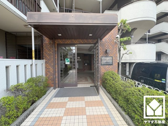 緑に囲まれたエントランスが、都会の喧騒を忘れさせる。自然と調和する、美しい迎賓空間。