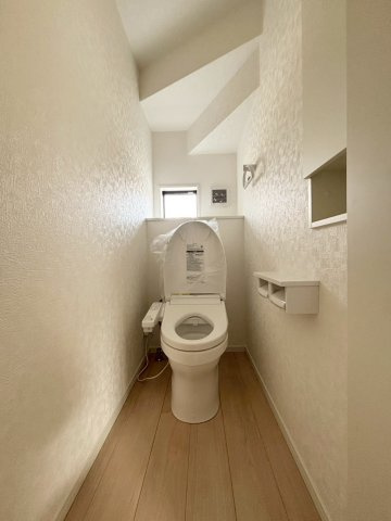 小窓が付いていて自然光が入り、いつでも明るい印象のトイレです！温水洗浄便座が標準装備されているため、寒い季節でもお尻が冷えずに快適。壁面の収納棚にはトイレットペーパーをスッキリしまえます♪