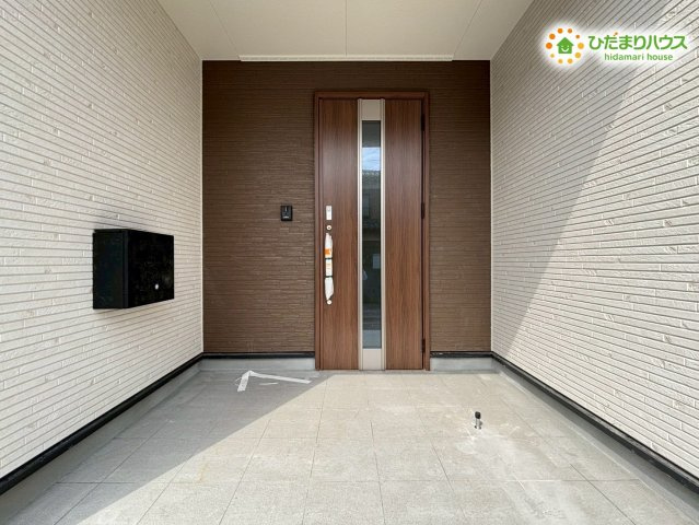 屋根のある設計で、雨の日でも濡れずに鍵を開け閉めできる玄関ポーチです！落ち着いた木目調のドアが明るい外壁に映え、自宅へ戻るたびに心がホッと休まるような雰囲気が演出されていますね♪