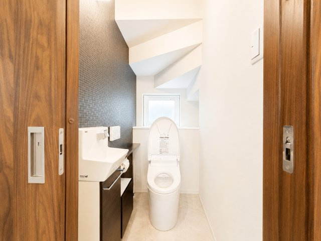 1階トイレは落ち着いたアクセントクロスが空間に上質感を与え、毎日気持ちよく利用できる空間です。手洗いカウンターを備えています。窓が設けられており、自然換気や採光ができるのも嬉しいポイントです。