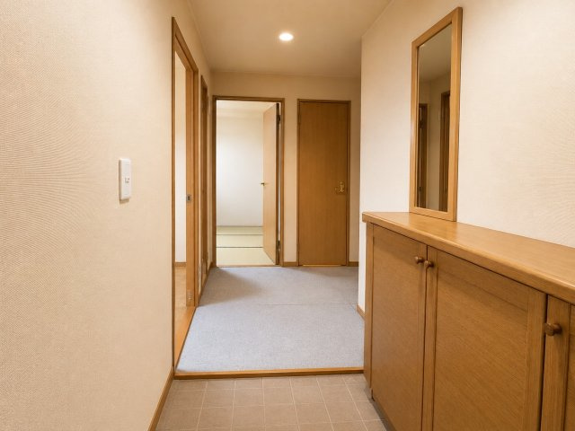 玄関から各居室へとつながる、ゆとりを感じられる空間です。木目調の建具と明るい色合いの内装が、温かみのある雰囲気を演出。シューズボックスも設けられており、靴や小物を整理しやすい造りです。