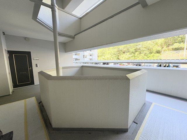 玄関前の共用廊下は、ゆとりのある広さと開放感が魅力です。外部に面した開口部から自然光が差し込み、明るい雰囲気を演出。屋根が設けられているため、雨の日も比較的濡れにくく、日々の出入りをサポートします。