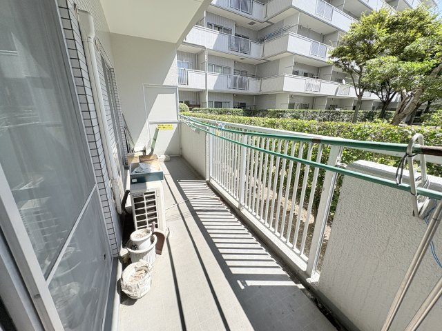 緑豊かな植栽を望む開放感のあるベランダ。物干し設備が設けられており毎日の洗濯物を干すスペースとして活用できます。奥行のある造りで室外機を置いても動線を確保しやすい印象。晴れた日には自然光が差し込みます