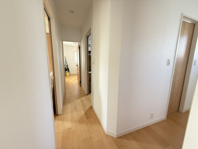 明るいフローリング仕上げの2階廊下。各居室へスムーズにアクセスできる動線で、プライベート空間をしっかり確保した間取りです。シンプルな内装で圧迫感がなく、家族が行き交う空間も快適に保たれています。　