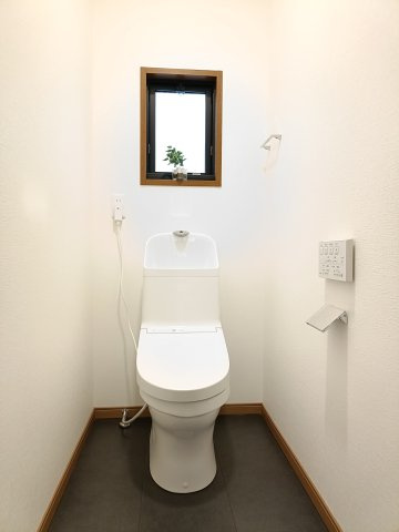 【トイレ】　壁付けの操作パネルを備えたウォシュレット付きトイレで、清潔に使用できます。