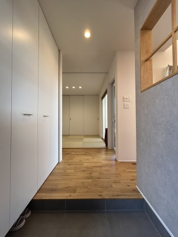 居室との調和を重んじた開放的な玄関。壁一面の収納には、ジャケット類も掛けられます。