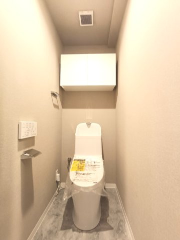 【トイレ】　トイレは温水洗浄便座付です。上部の吊戸棚でストック品もすっきり収納できます。