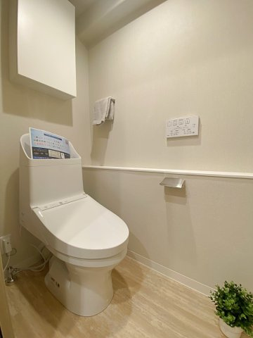 清潔感あふれる新規交換済みの温水洗浄便座付きトイレです。節水型で経済的な最新設備を採用しており、毎日快適にご使用いただけます。上部にはトイレットペーパーなどを整理できる便利な収納棚を完備しています。