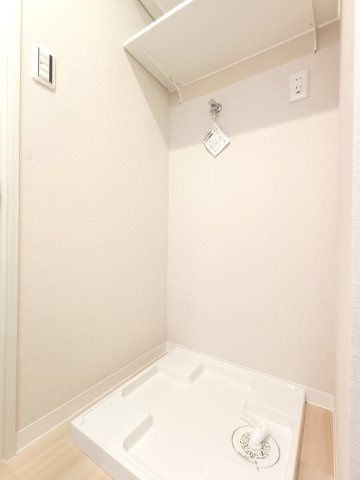 【室内洗濯機置き場】　壁面に棚が造作されています。洗剤のストックやタオルなどを収納できます。