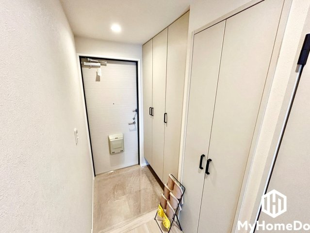 壁面に沿って天井近くまで高さのあるシステム収納が設置されており、家族全員の靴類をすっきりと収められます。