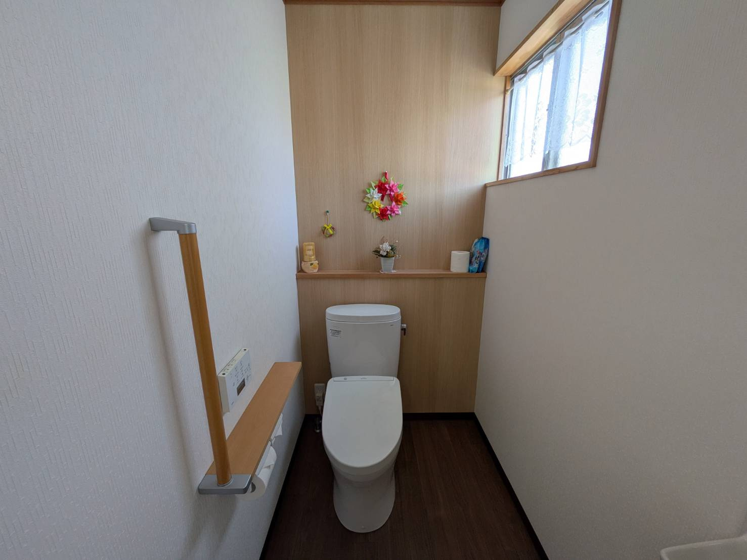 シンプルで清潔感のあるトイレ空間。手すりが設置されており、どなたでも安心してご利用いただけます。窓付きで換気ができる点もポイント。コンパクトながら使い勝手に配慮された設計で、日々の生活を快適にサポート