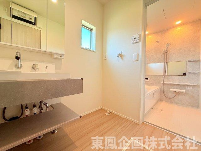 統一感のあるデザインでまとめられた洗面脱衣所と浴室。