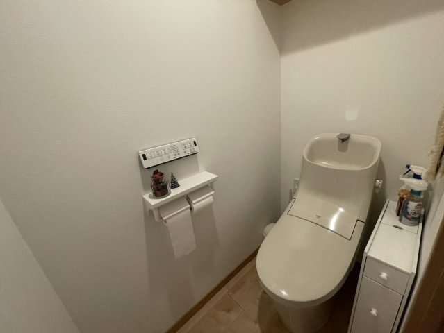 シンプルで落ち着いた雰囲気のトイレ空間。温水洗浄便座付きで快適性にも配慮されています。上部収納を備え、備品や掃除用具の置き場にも困りません。毎日使う場所だからこそ、清潔感が際立ちます。