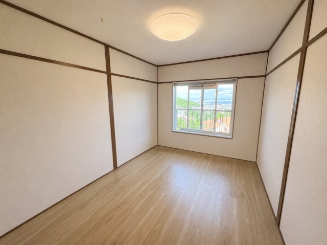 窓から開放的な景色が広がります。高台ならではの、心地よい眺望が楽しめる洋室6帖のお部屋です。窓の外には遮るものがなく、遠くの街並みや緑を見渡せます。　（CG加工による家具消しを行っております。）