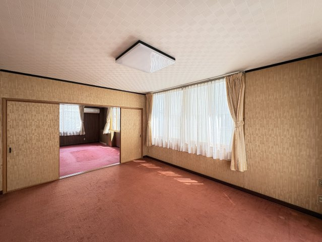 広さにゆとりのある洋室で、落ち着いた雰囲気のカーペット仕様。隣室とつながる間取りのため、用途に応じて広く使うことも可能です。大きな窓から自然光が差し込み、明るく開放的な住空間を演出します。