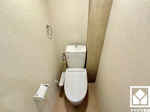明るく清潔感溢れるトイレです。タオル掛けやペーパーホルダーが設置されています。居住性と機能性を重視した無駄のないレイアウトで、快適な日常生活をサポートします。