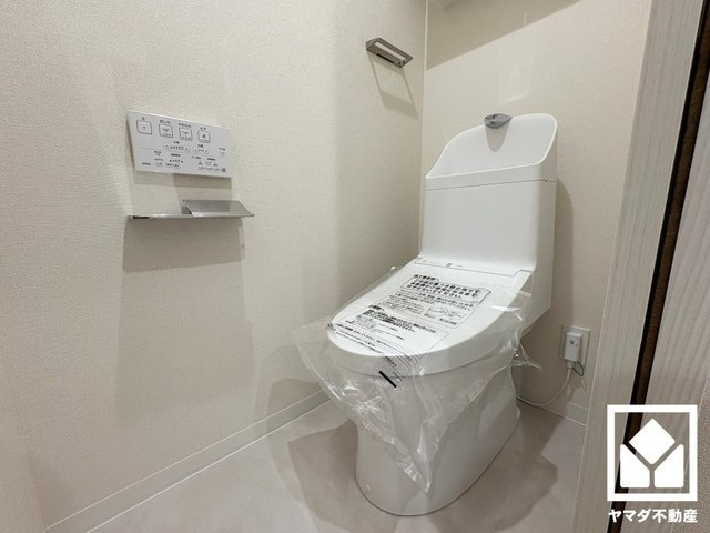 明るく清潔感溢れるトイレです。トイレットペーパーのストックや消耗品置き場などとしてお使いいただける吊戸棚がございます。