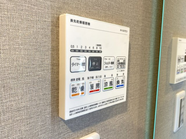 浴室暖房換気乾燥機のリモコンパネル。ワンタッチで雨の日の衣類乾燥や冬場の予備暖房、夏の涼風機能などを簡単に切り替え可能です。日々の家事を効率化し一年中快適なバスタイムを支える先進の設備となっています。