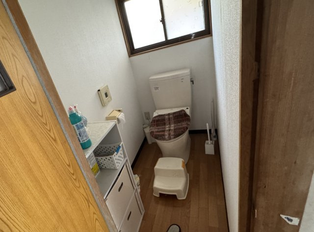 窓付きで換気がしやすいトイレ空間。必要な収納棚も設けられており、日用品の整理がしやすい点もポイントです。設備更新によって快適性を高めることで、より使いやすい水回りへとアレンジが可能です。