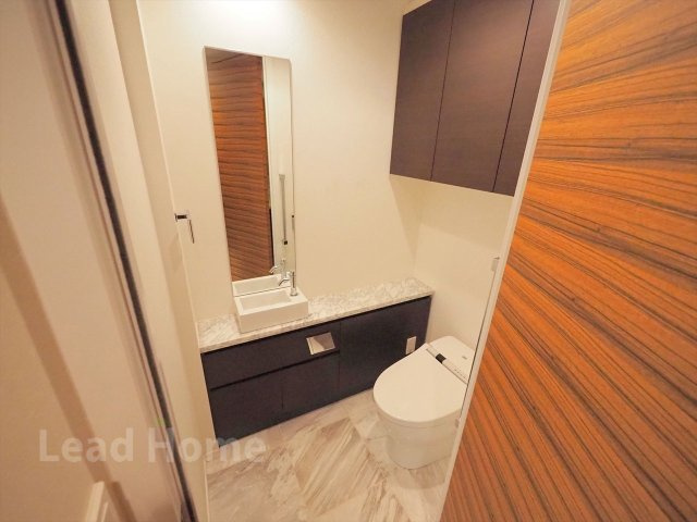 手洗いカウンターと上部棚を備えたスタイリッシュなトイレです！清潔感のある空間で快適に使えますね♪