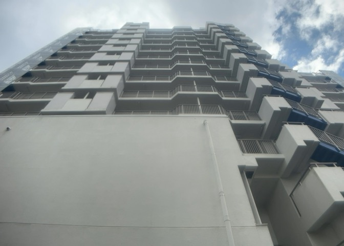 マンション敷地内の共有空間の一角です。鉄筋コンクリート造13階建ての建物に囲まれたスペースで、通行者の安全や日々の維持管理に配慮された開放感のある配慮がなされています。現地の状況をご確認ください。