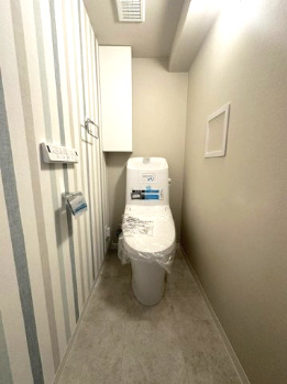 温水洗浄便座付のトイレで、冬の寒い時期でも快適！吊戸棚付きで、予備のペーパー類も問題なく収納できます。