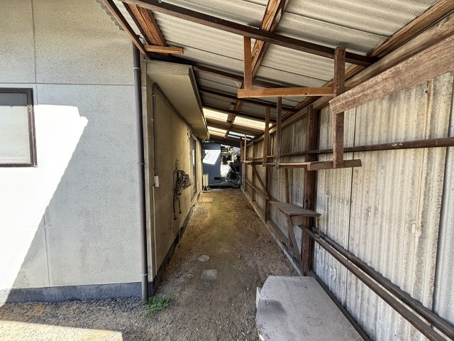 建物横には屋根付きのスペースがあり、雨の日でも作業や物置として利用しやすい環境です。棚も設けられているため工具や資材などを整理して保管することも可能。自転車置場やアウトドア用品の保管場所としても活用。