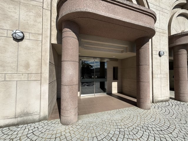 重厚感のあるデザインが印象的なエントランス外観。大きなアーチ状の柱が建物全体に高級感を演出します。段差の少ないアプローチでベビーカーやキャリーケースの出入りもスムーズです。品格ある佇まいが魅力です。