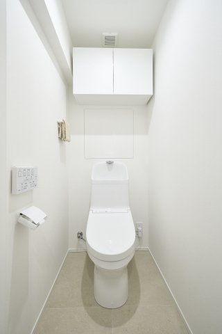 清潔感のあるホワイトでまとめられたレストルーム。温水洗浄便座を標準装備し、毎日の快適をサポートします。上部には吊戸棚があり、ストック品を隠して収納できるため、空間の美観を損ないません。