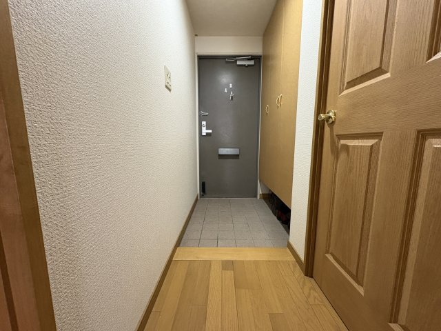 落ち着いた印象の玄関スペースです。大型のシューズボックスを備え、靴や小物をすっきり収納できます。廊下がまっすぐ伸びており、各居室への動線も分かりやすい設計となっています。